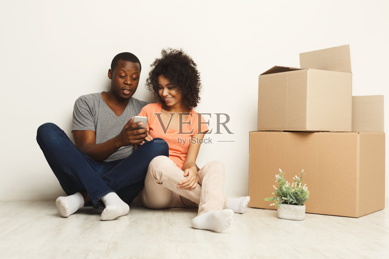 非裔美国人坐在新公寓的地板上照片摄影图片