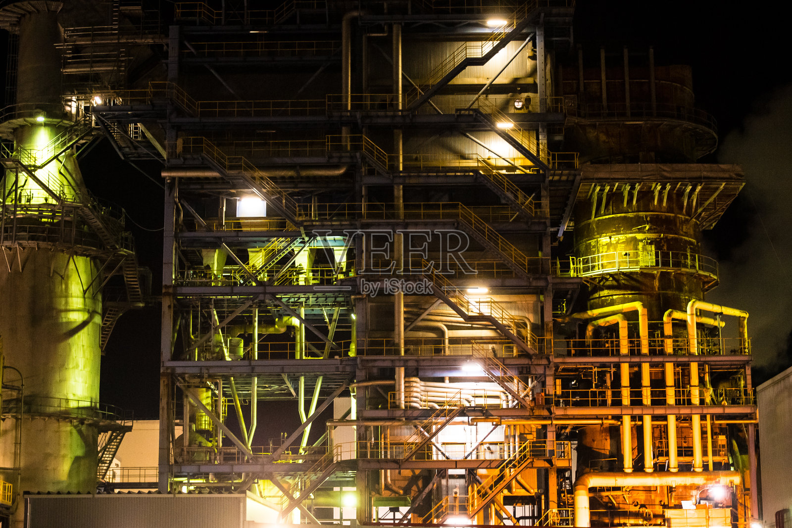 晚上是工业区。建筑物就像生物一样在夜晚呼吸。照片摄影图片