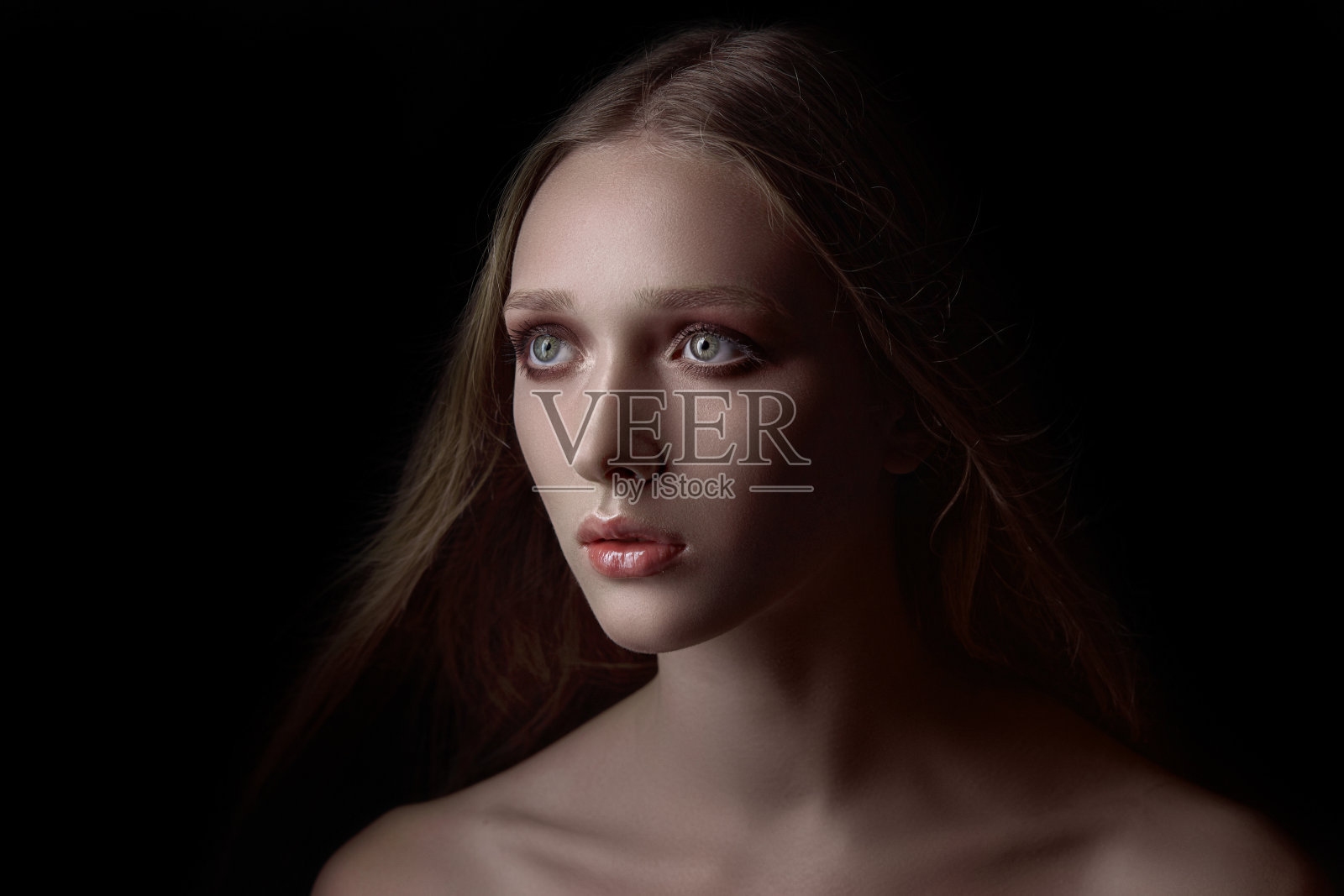 时尚肖像的金发女孩与红眼睛在黑色照片摄影图片