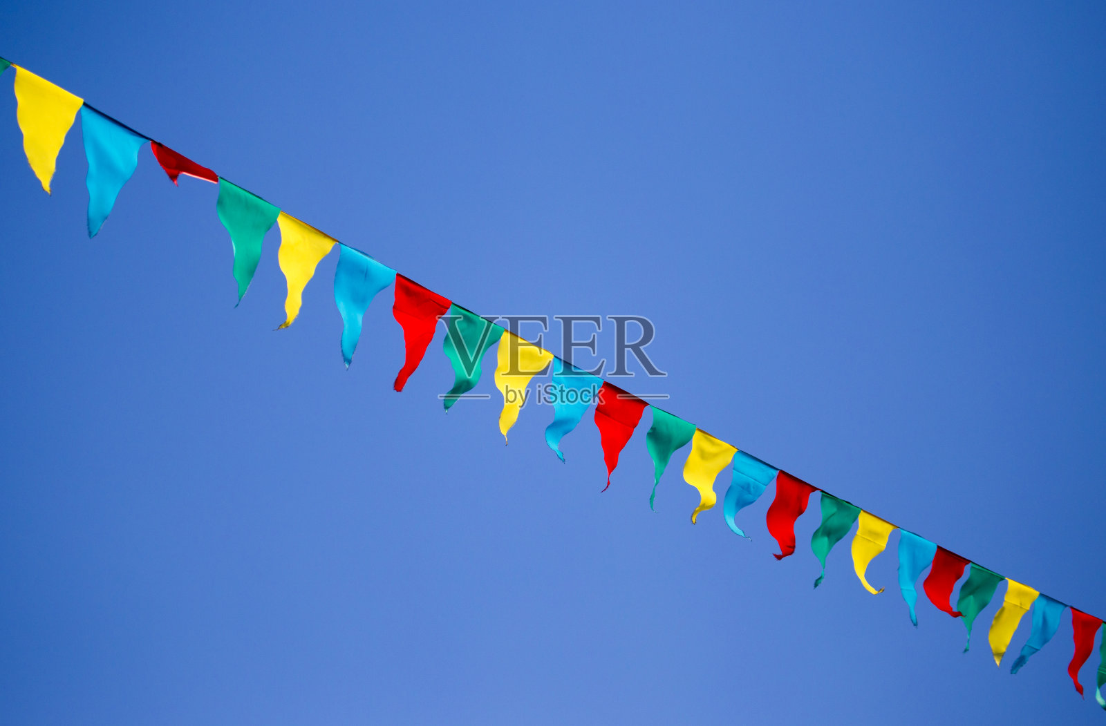 蓝天映衬着五光十色的旗帜照片摄影图片