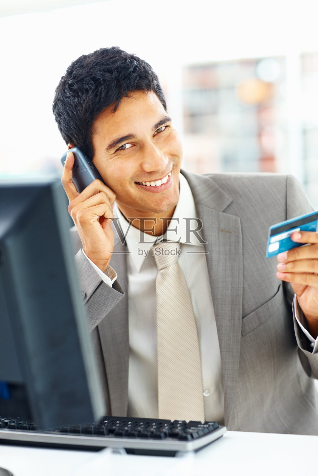 快乐的年轻商人在网上购物,同时打电话照片摄影图片