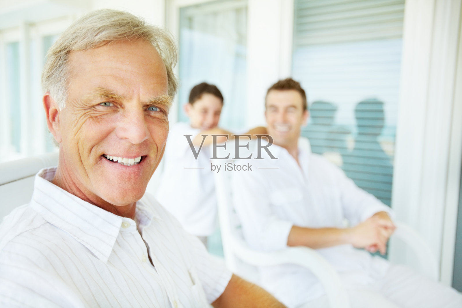 一位老人面带微笑,身后是家人照片摄影图片