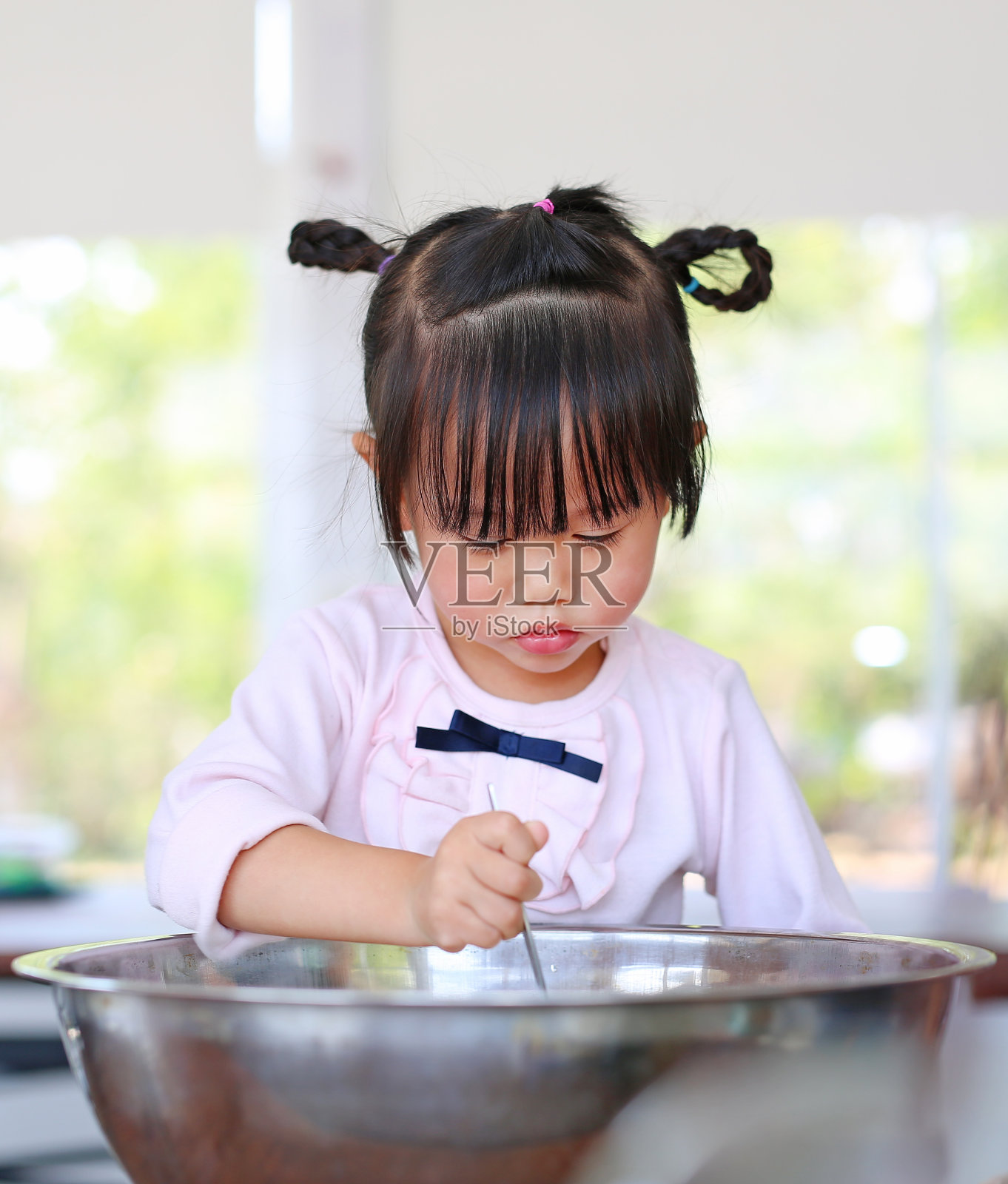 小女孩在做煎饼。照片摄影图片