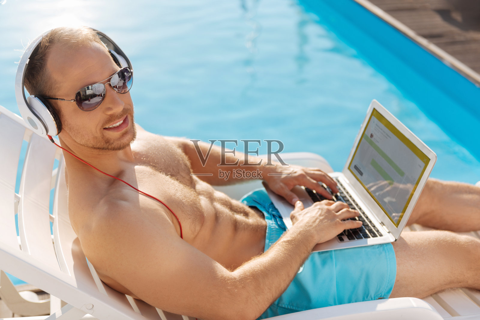 小伙子一边晒日光浴一边开发应用程序照片摄影图片