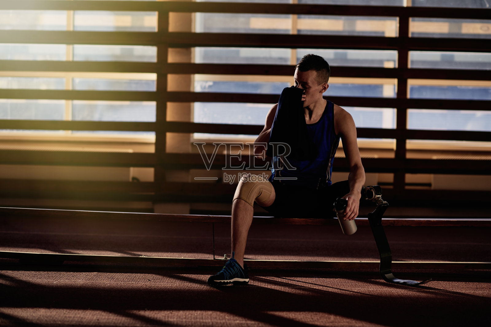 坐在长凳上的残疾人运动员照片摄影图片