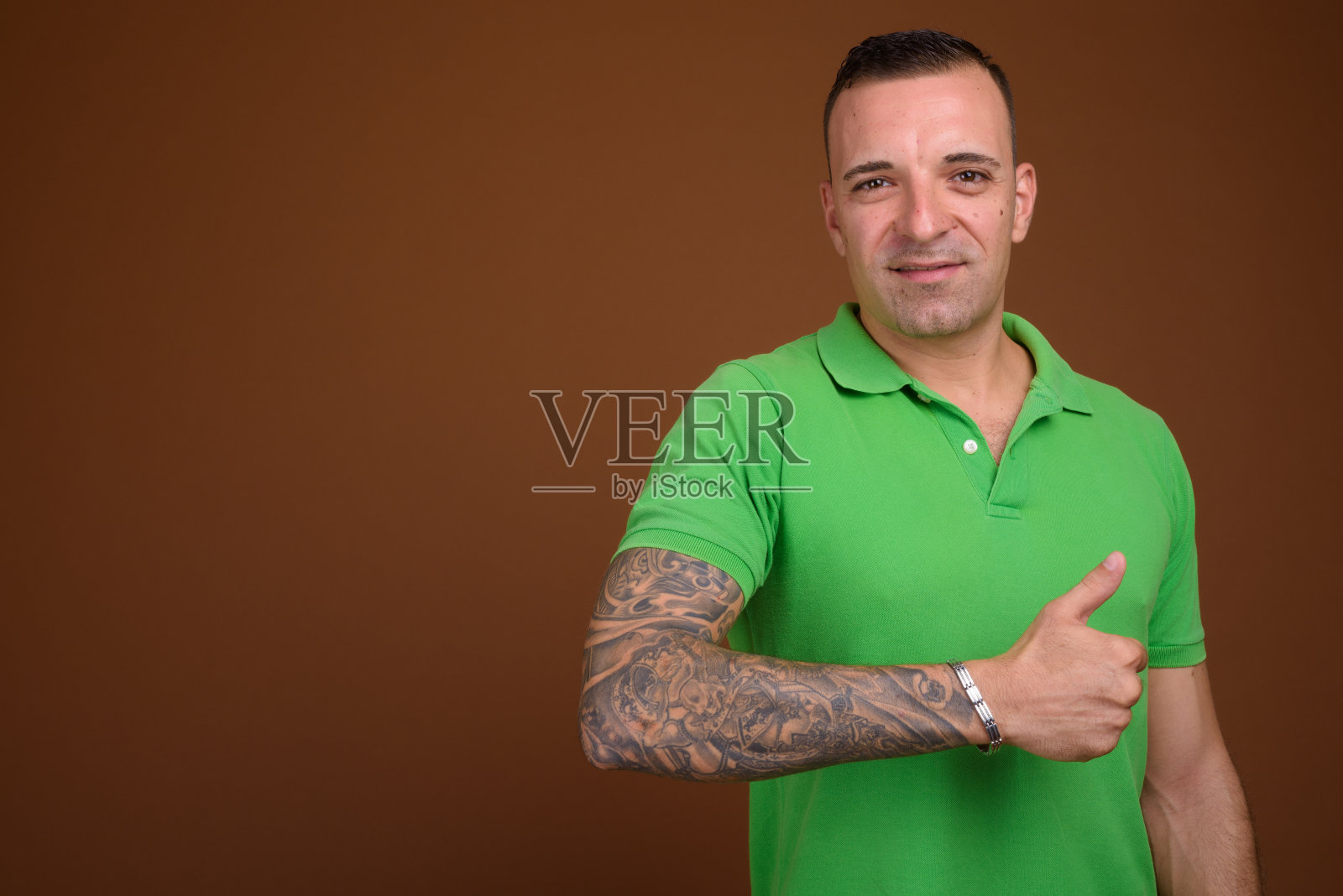 摄影棚里的男人穿着绿色马球衫,背景是彩色的照片摄影图片