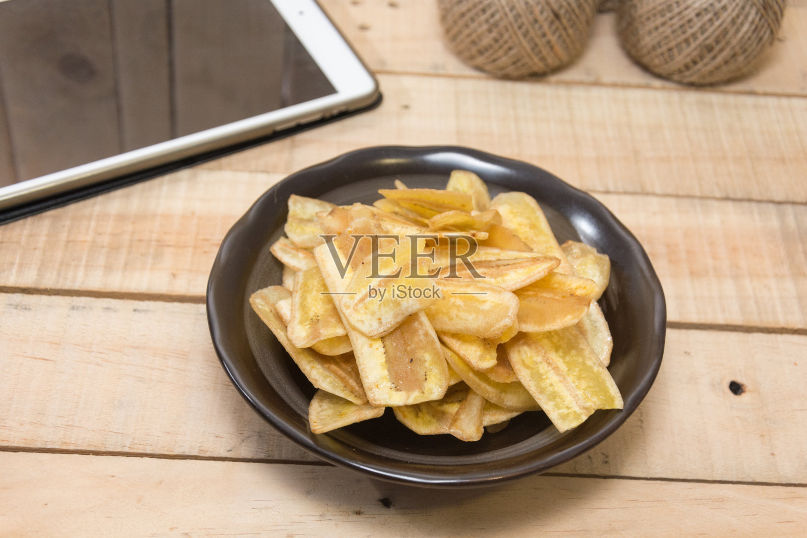 甜香蕉薯片放在木碗里照片摄影图片