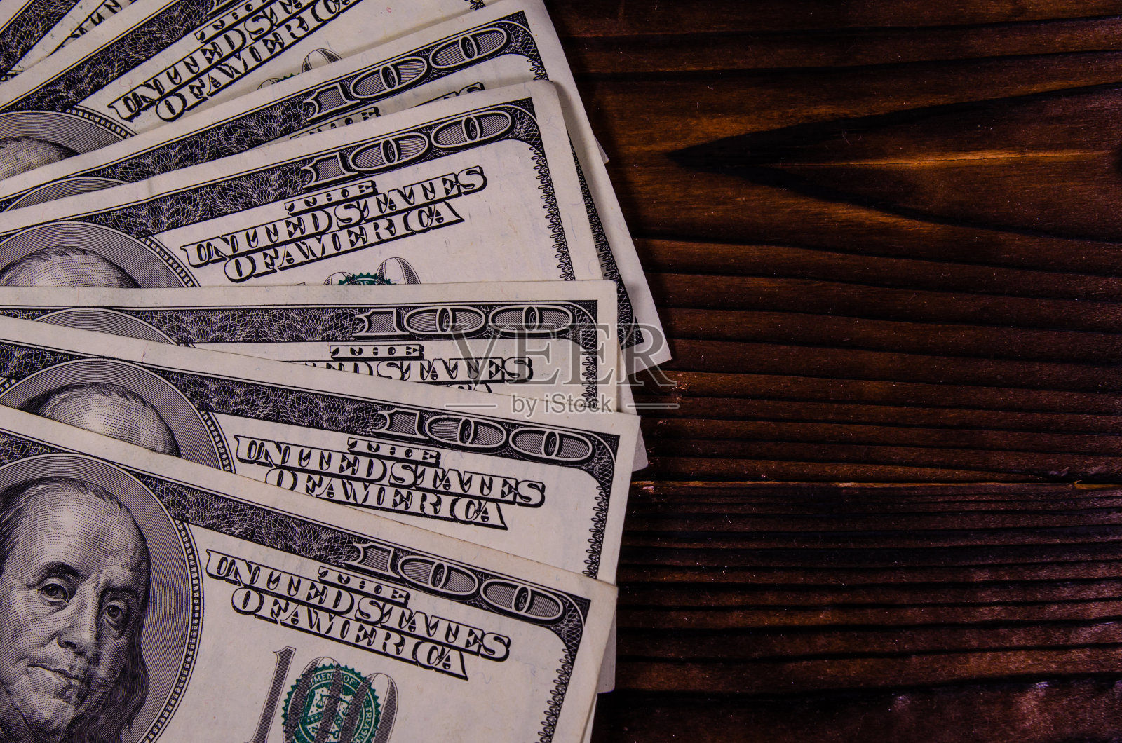 一百美元的钞票放在木桌上。俯视图照片摄影图片