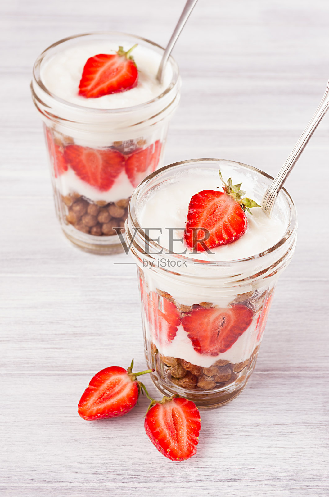 早餐有草莓和巧克力球,玉米粒放在白色木板上。照片摄影图片