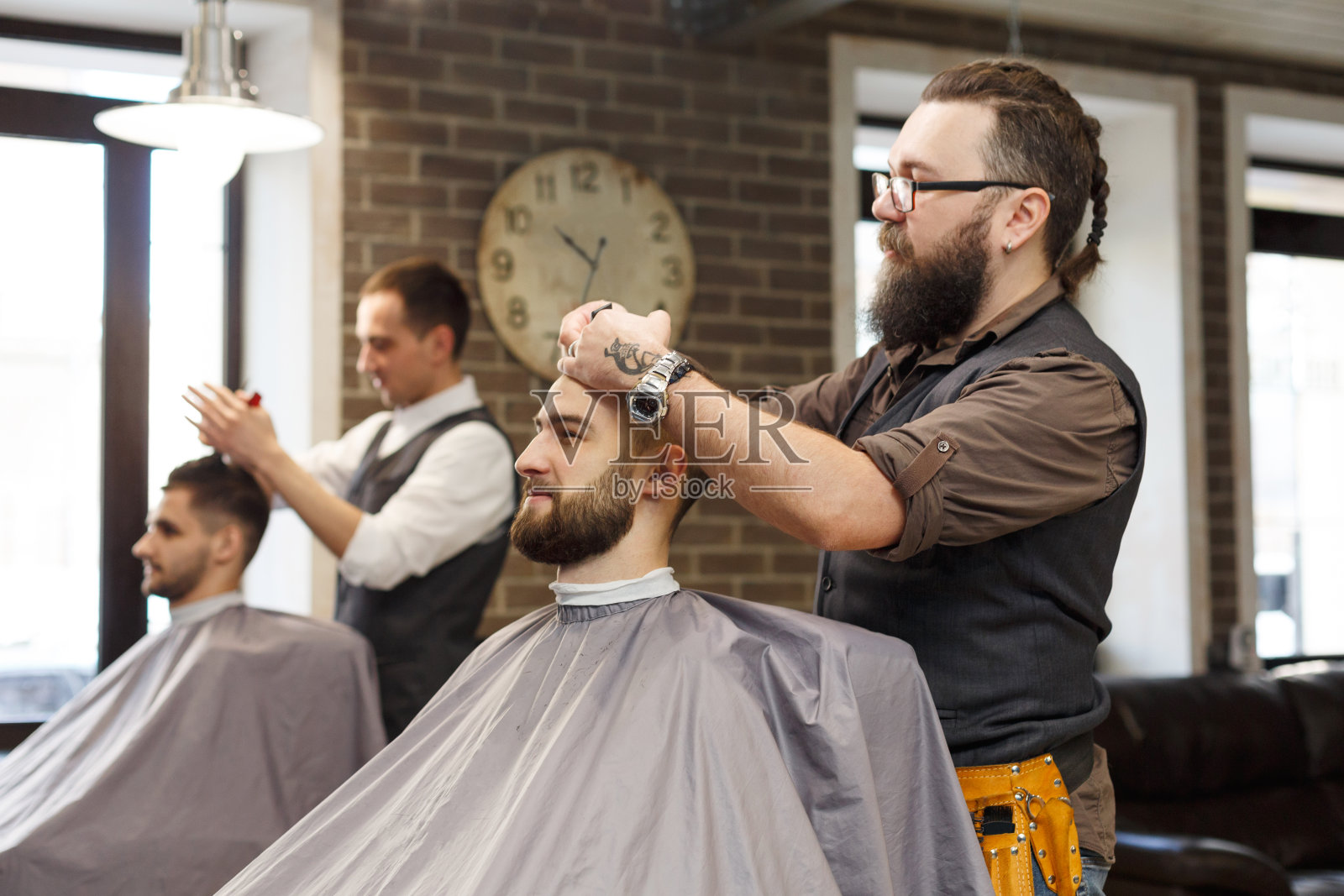 理发师在理发店用剪刀给顾客理发照片摄影图片