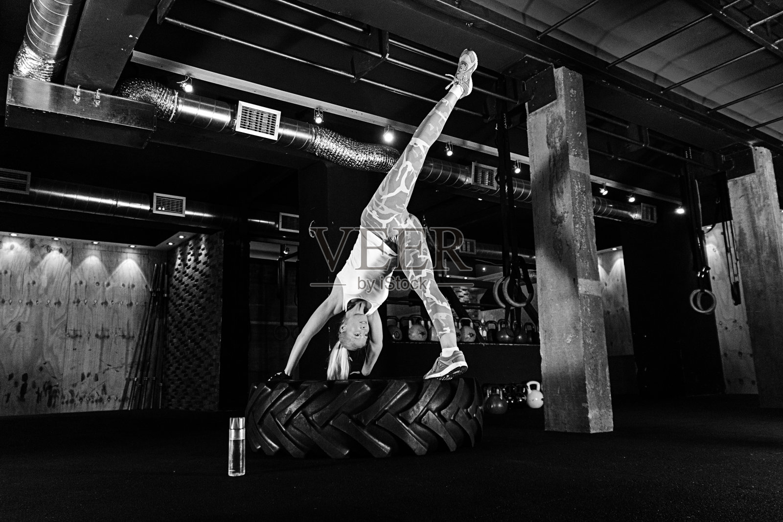 用轮胎锻炼。黑白健身女性照片摄影图片