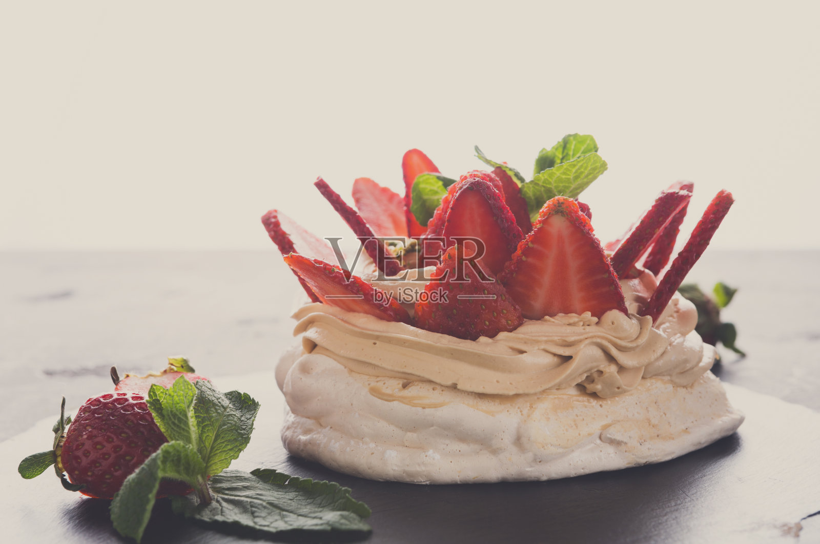 以草莓为背景的安娜巴芙洛娃蛋糕照片摄影图片