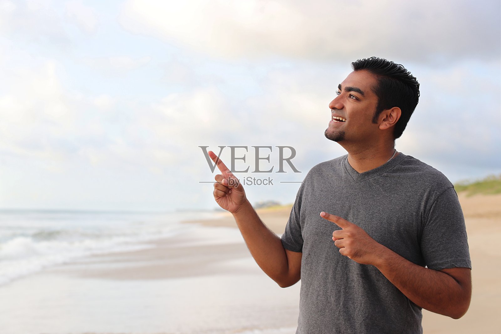 帅哥站在海滩上照片摄影图片