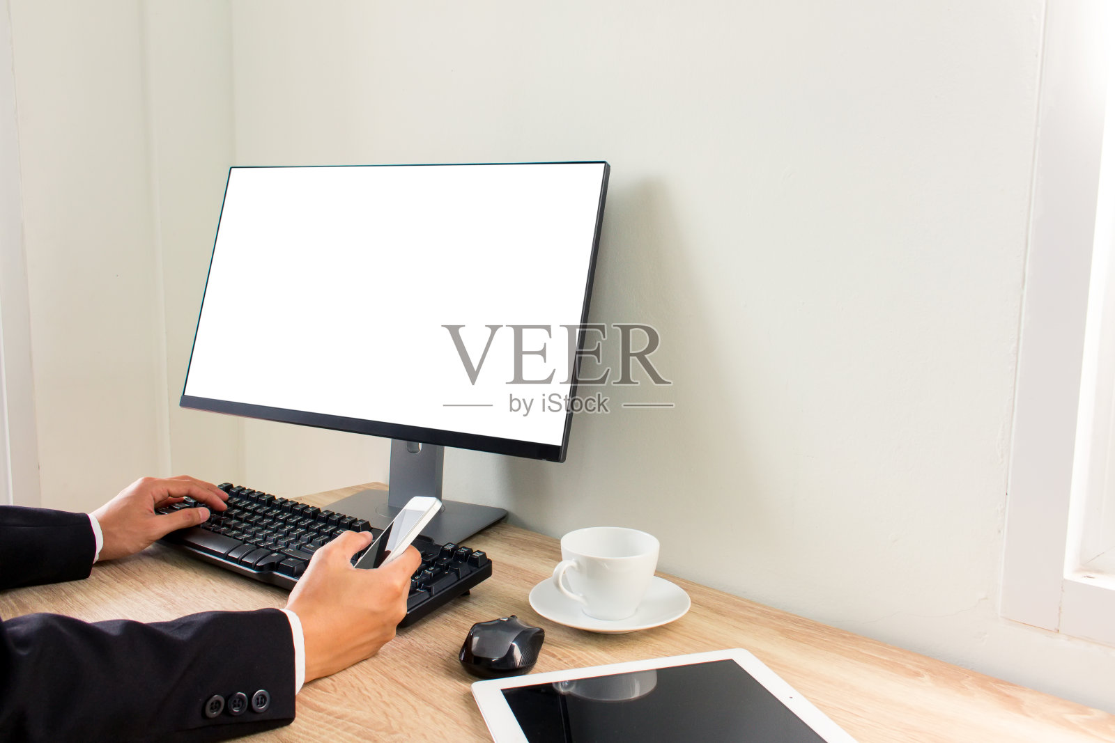 商人使用智能手机和平板电脑在办公室工作照片摄影图片