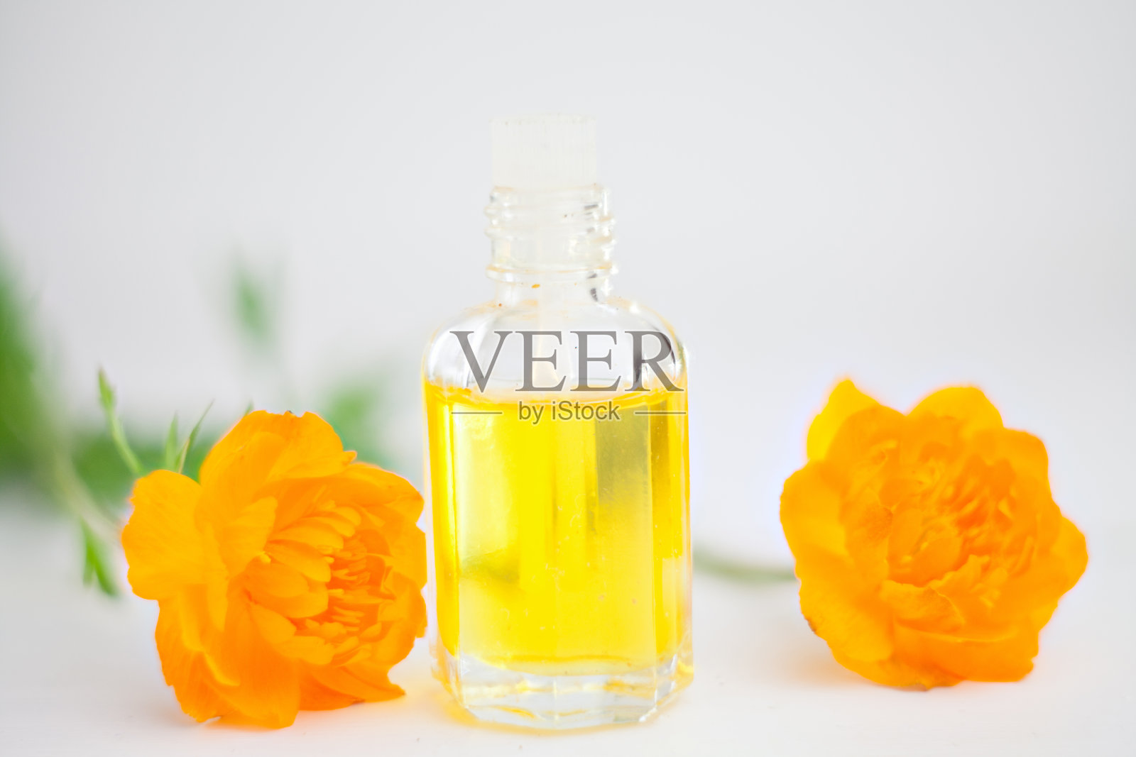 香精油在桌子上的漂亮的瓶子与鲜花照片摄影图片