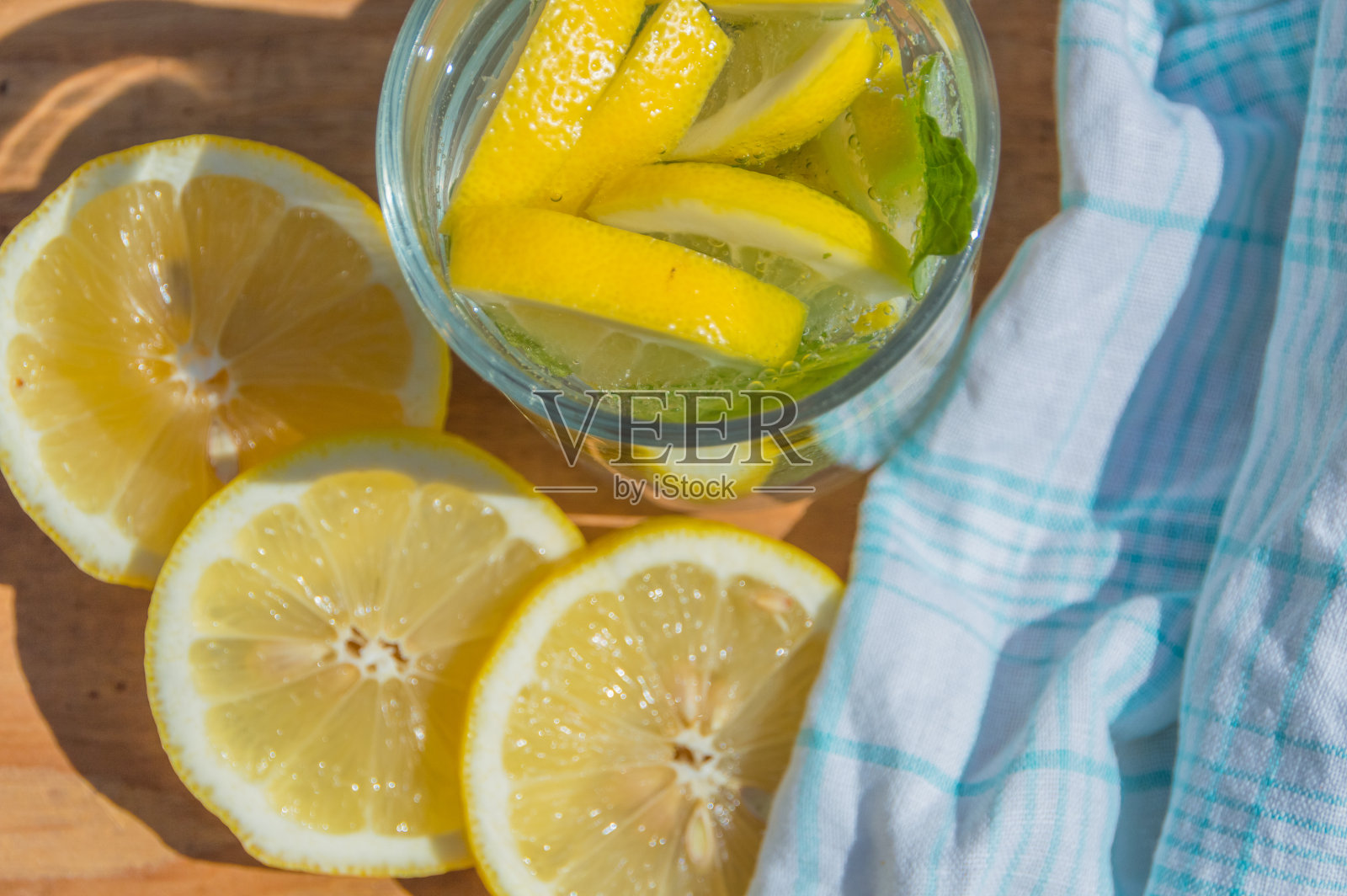 木制的桌子上放着柠檬和薄荷苏打水,从上面看风景照片摄影图片