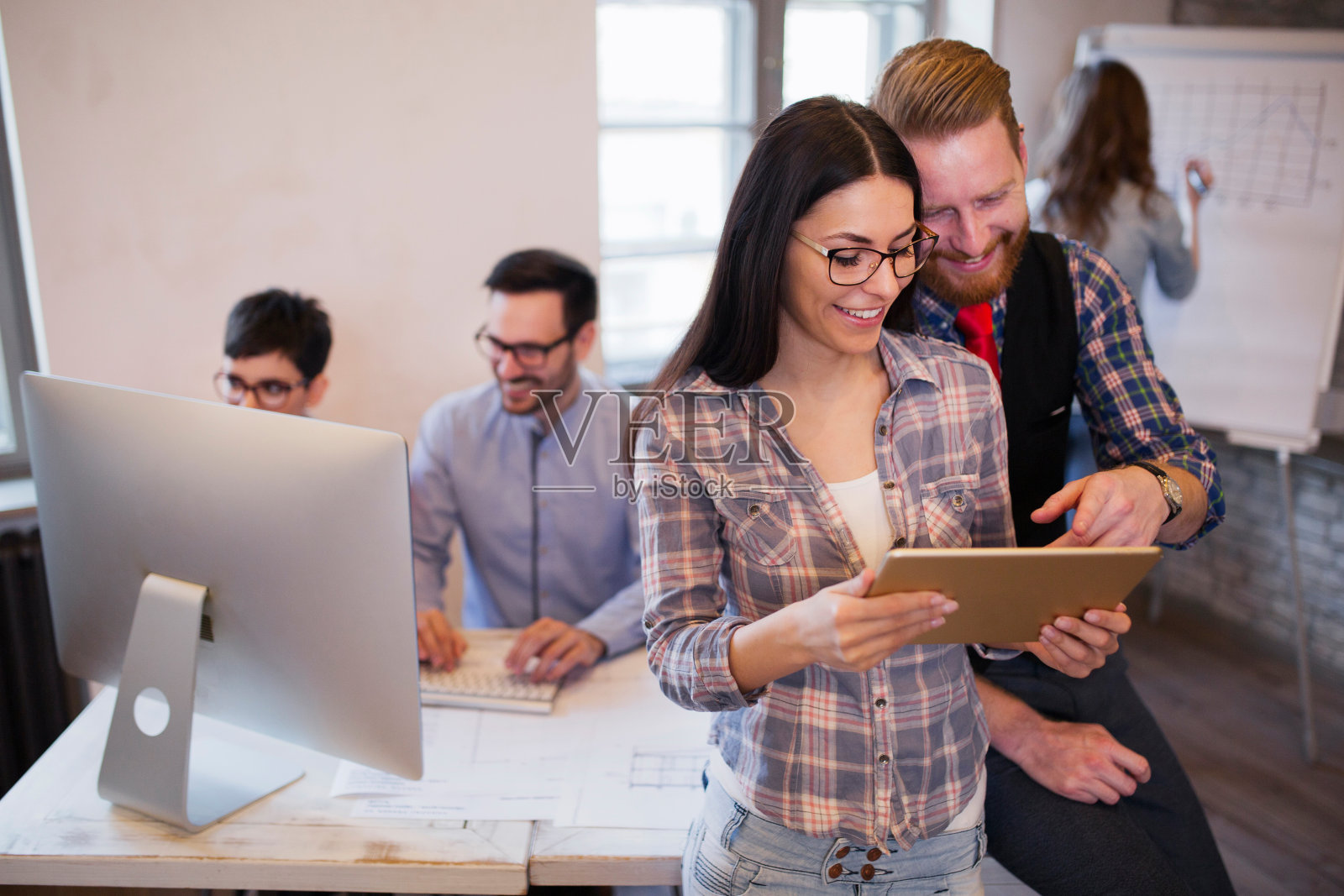 年轻有吸引力的设计师谈论和看数字平板电脑照片摄影图片