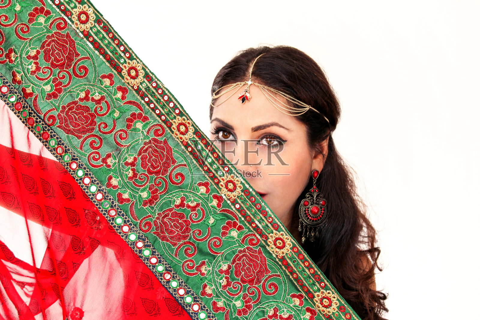 穿着民族服装跳印第安舞的妇女。一个英俊美丽的女孩肖像,穿着红色的印度纱丽,为印度号角舞的动作。穿着传统服装的印度舞者。宝莱坞舞蹈。美。照片摄影图片