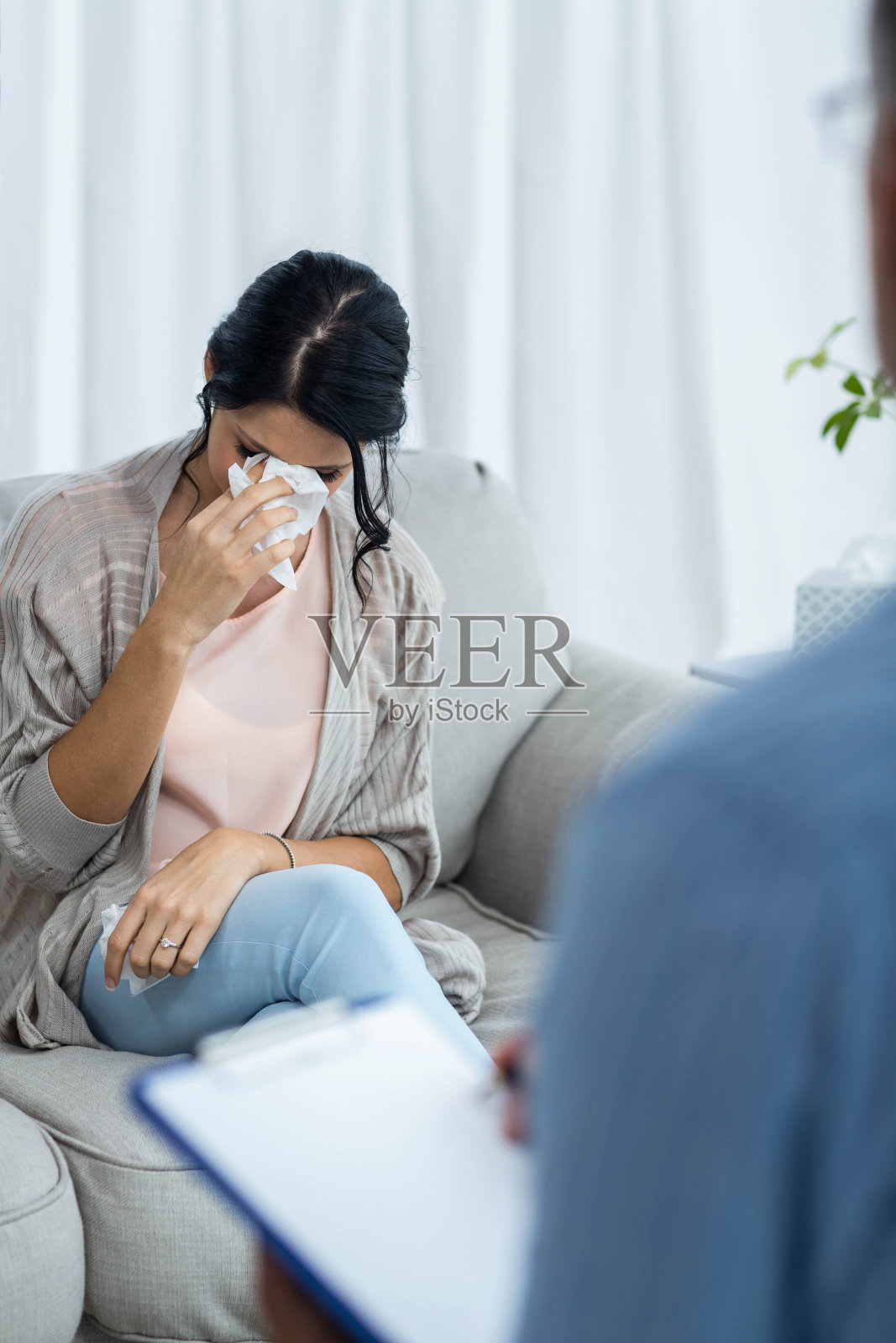 医生一边向孕妇咨询一边在写字板上写字照片摄影图片