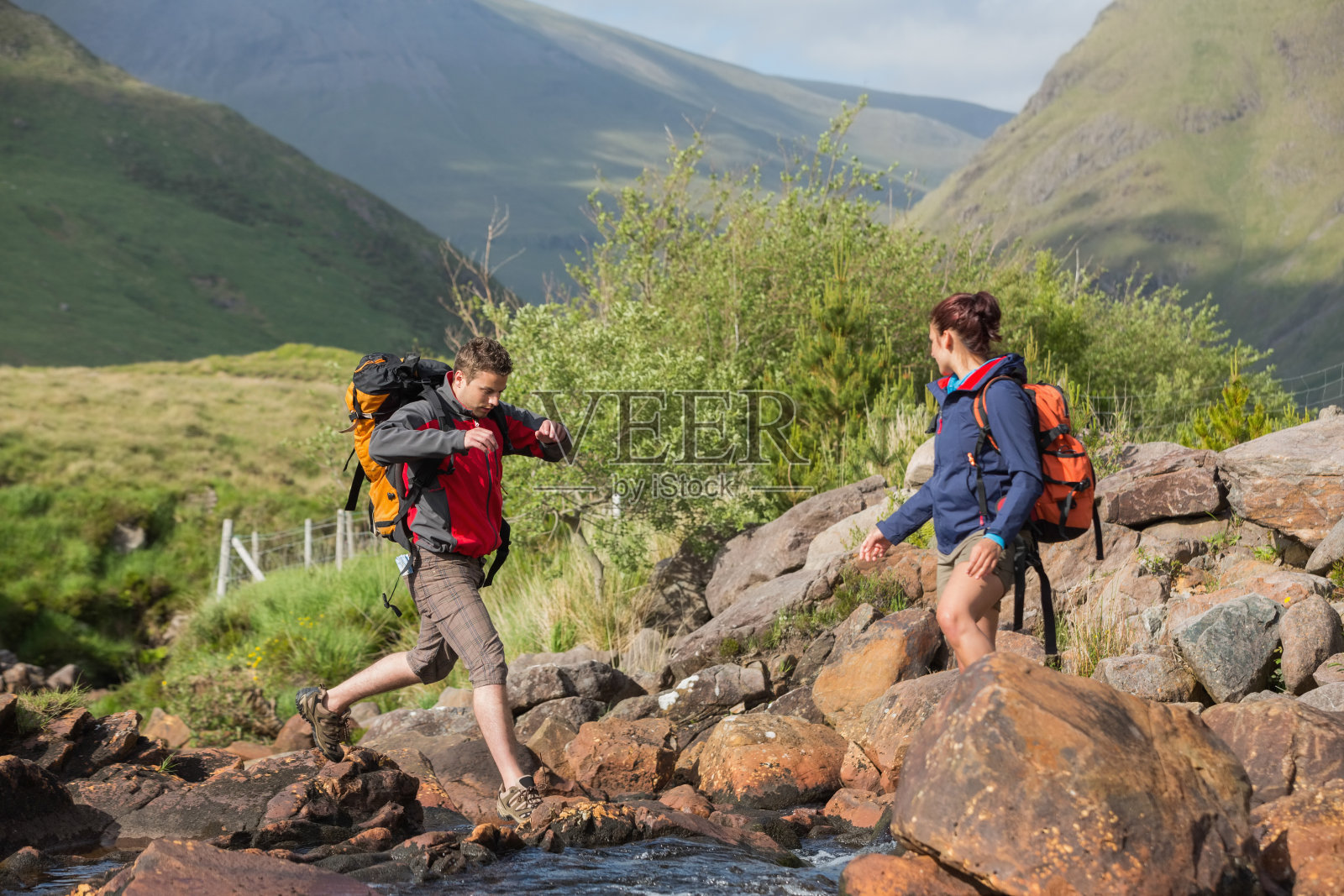 一对徒步穿越河流的夫妇照片摄影图片