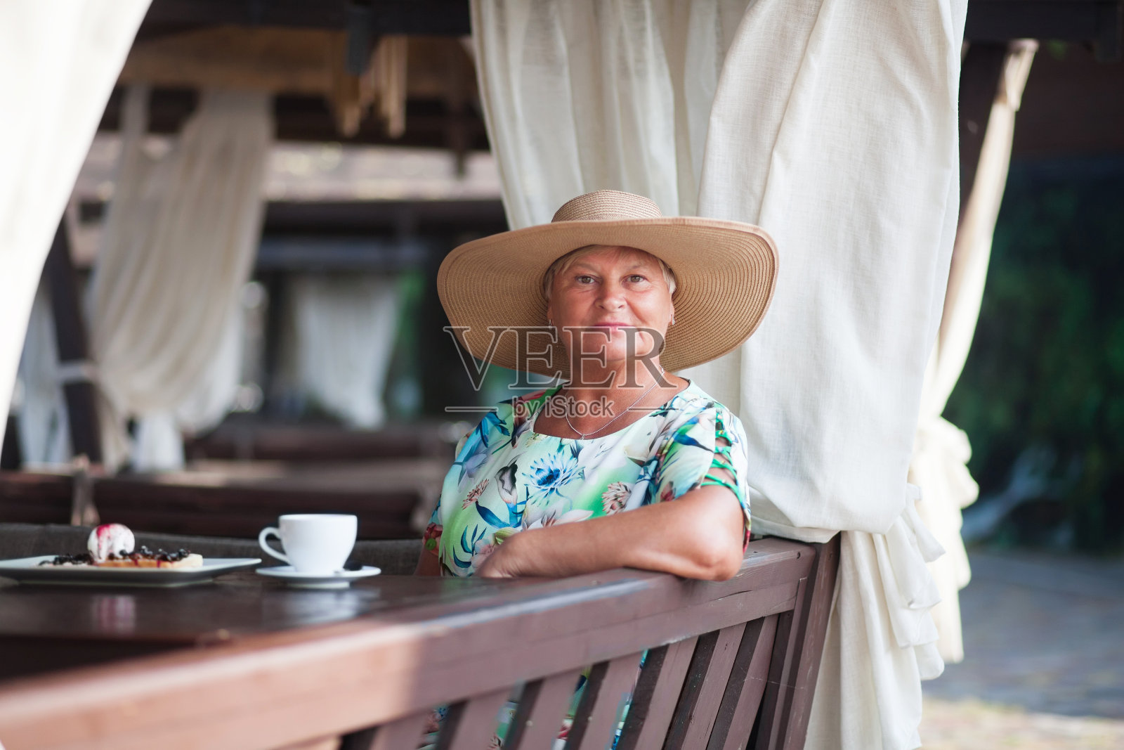 一位老妇人坐在咖啡馆里照片摄影图片