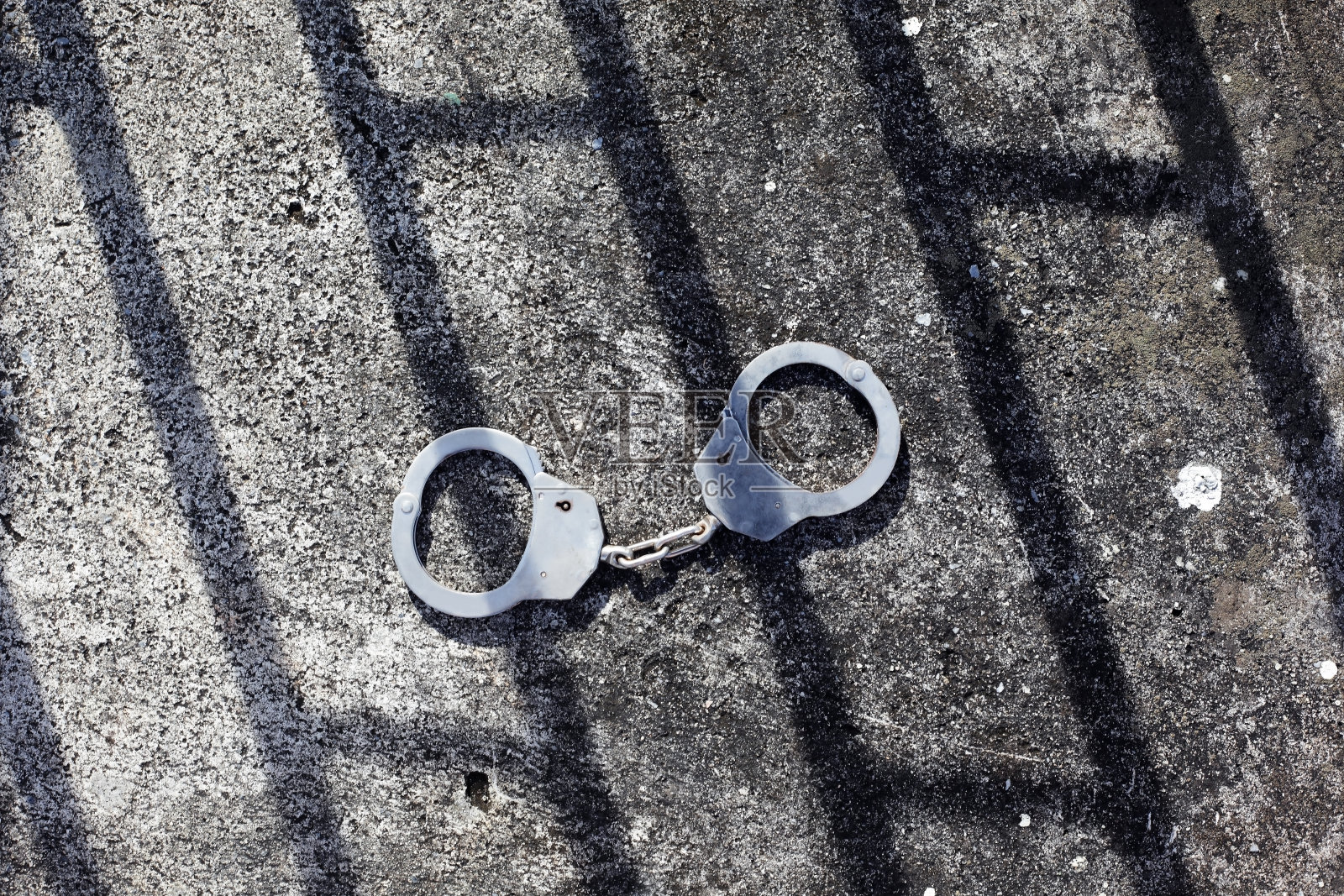 手铐和监狱的影子作为背景。照片摄影图片