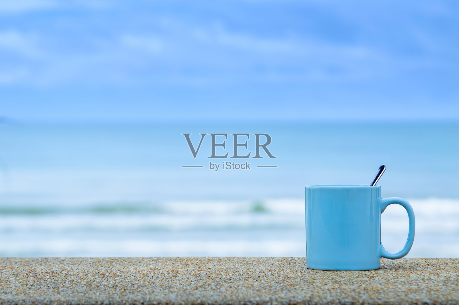 蓝色的杯子在蓝色的大海和天空的海滩上照片摄影图片