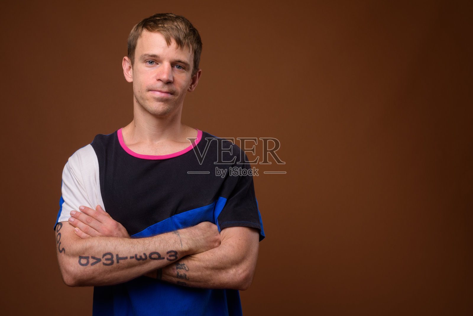 在彩色背景的衬托下,一名男子穿着多色衬衫照片摄影图片