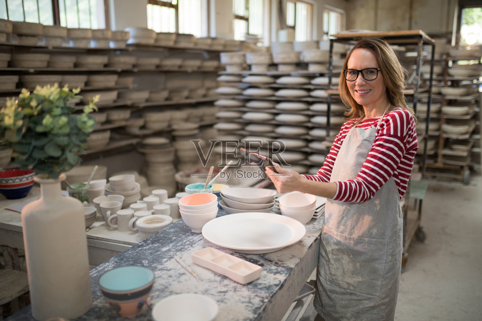 女性陶工的肖像使用数字平板电脑照片摄影图片