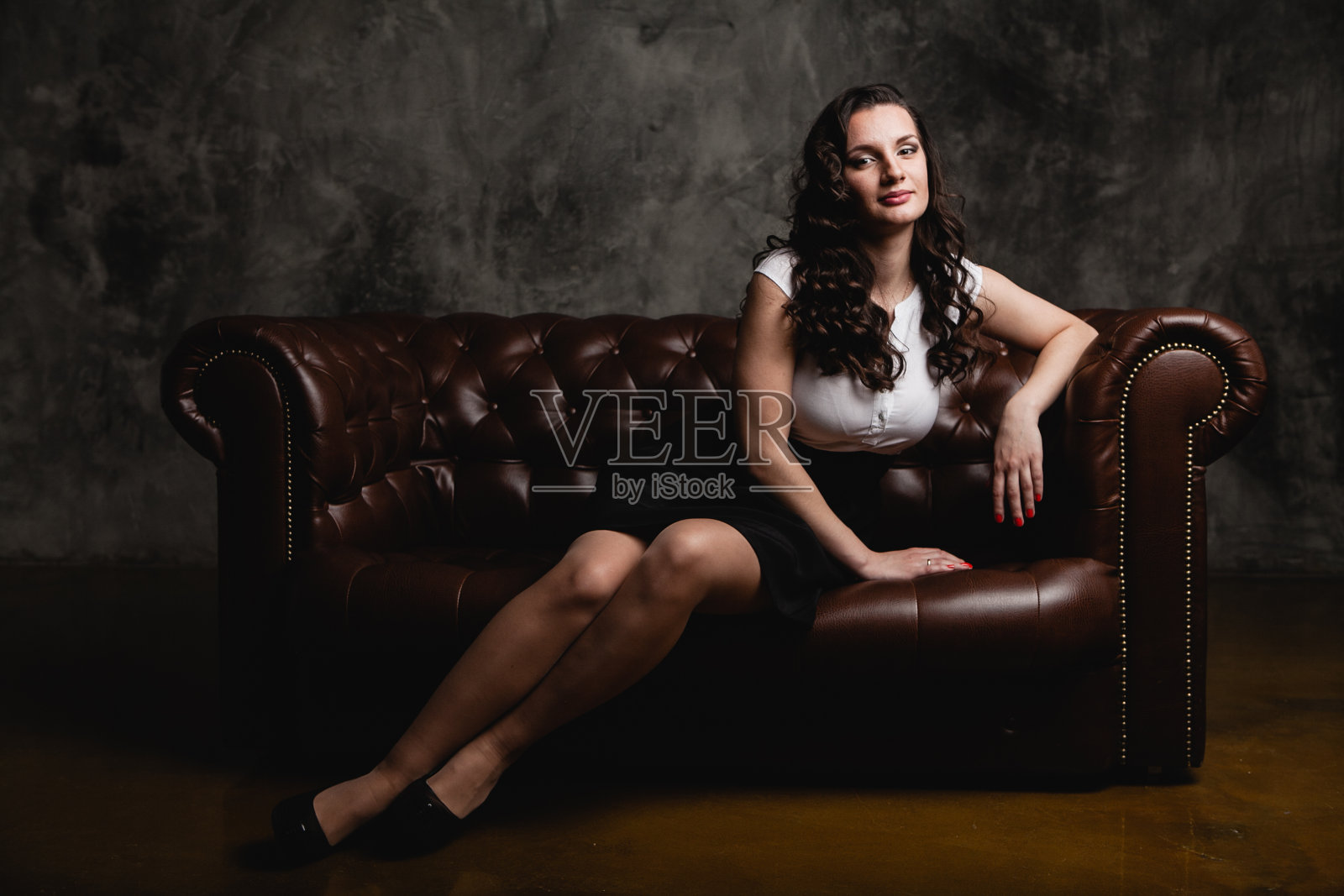 漂亮女人坐在沙发上照片摄影图片