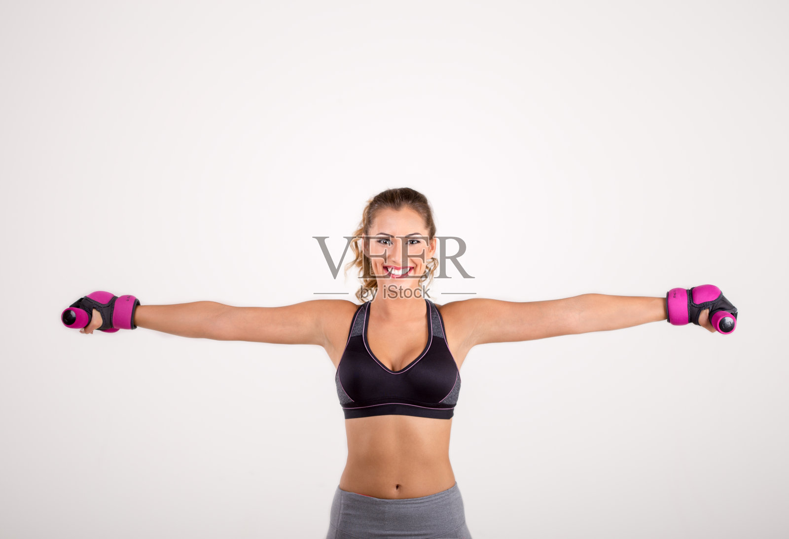 快乐的健身女人拿着哑铃微笑着照片摄影图片