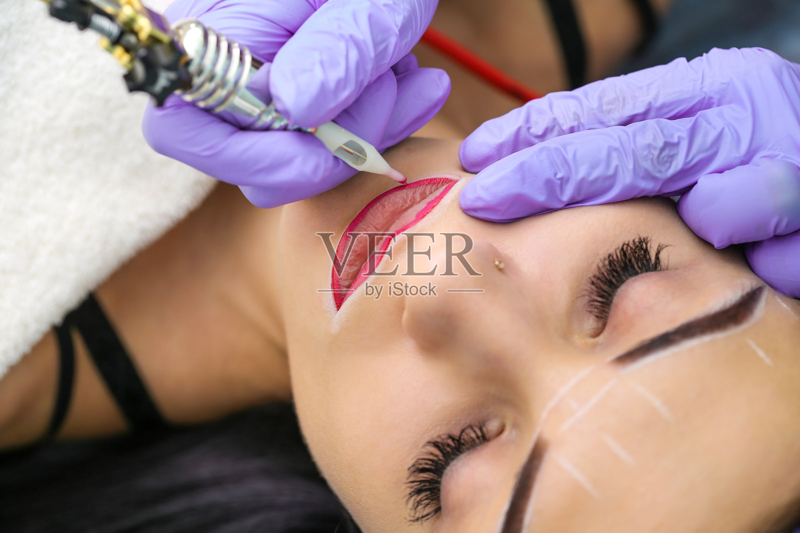 美容师在女人脸上做永久化妆照片摄影图片