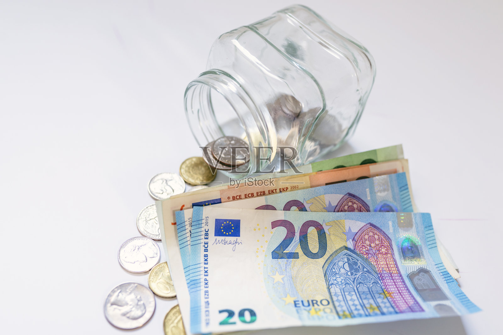 储蓄,金钱,年金保险,退休和人的概念。25、钱与储蓄相存,孤立于白色。在白色的背景上孤立的玻璃罐中节省欧元照片摄影图片