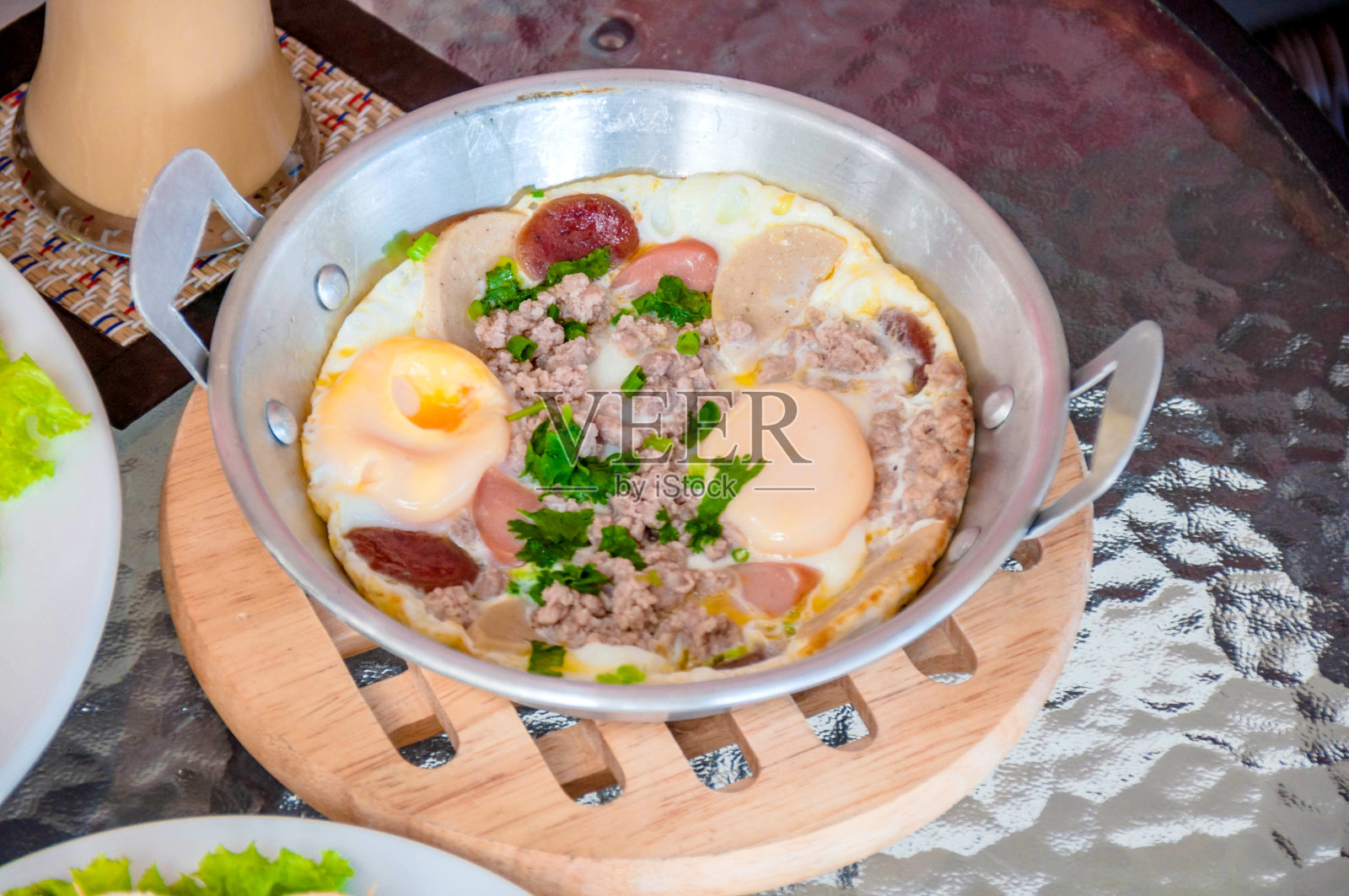 早餐在平底锅里煎蛋,熏肉和蔬菜在黑暗的背景,俯视图照片摄影图片