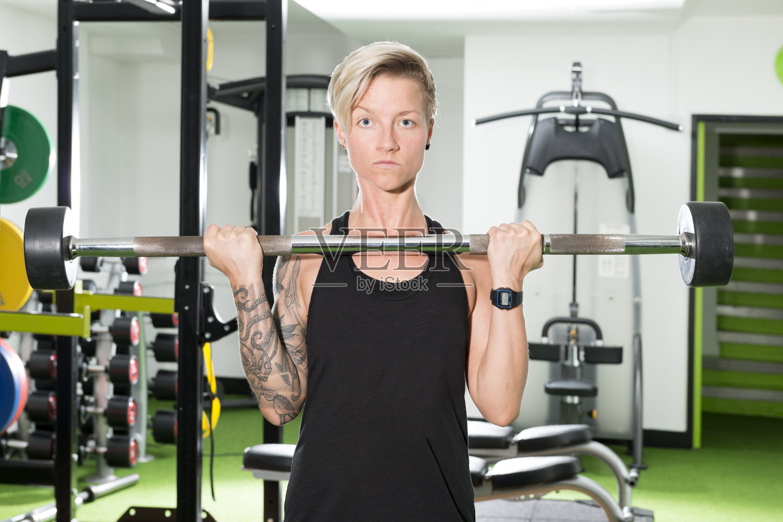 运动纹身女人在健身房举杠铃照片摄影图片