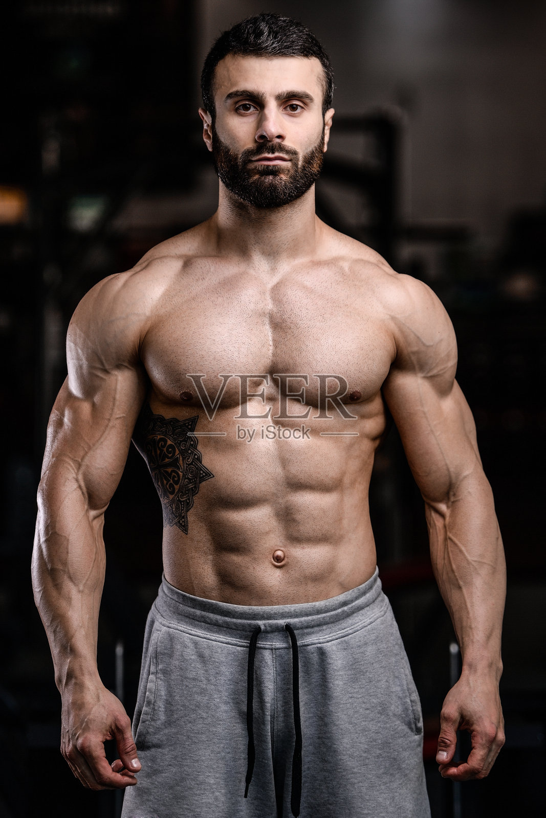 白种人性感健身模型在健身房接近腹肌照片摄影图片