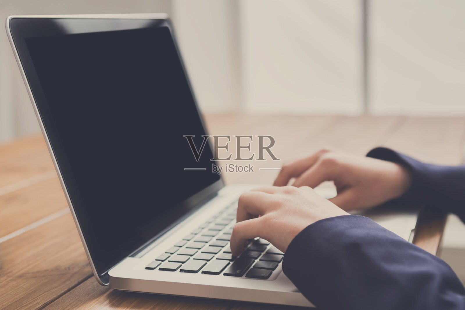 商务女性在工作场所使用笔记本电脑,特写照片摄影图片