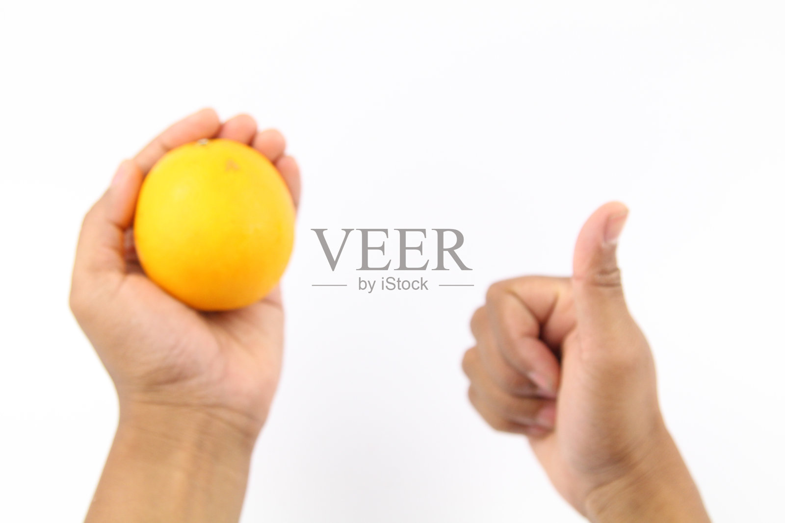 手握橙,大拇指向上照片摄影图片