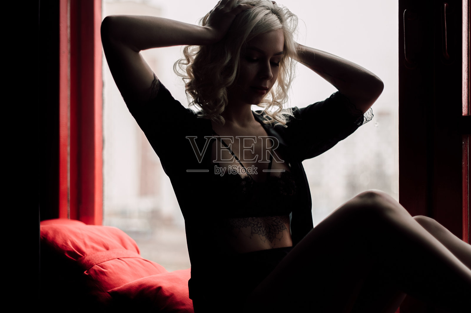 美丽的时尚模特性感和热情的金发女人与红色的嘴唇摆pose靠近窗户穿着黑色性感内衣照片摄影图片