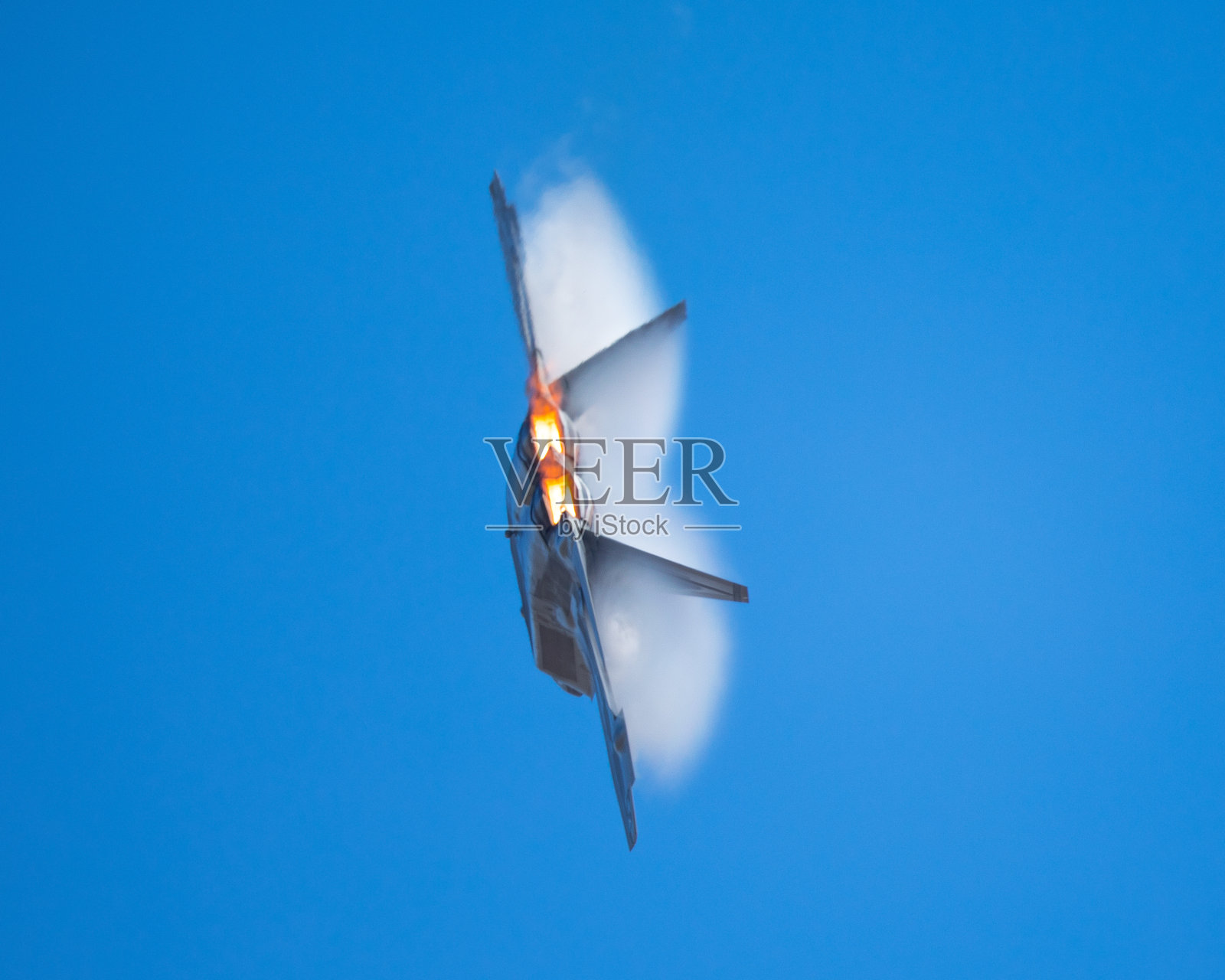 军用飞机在高g机动,与加力燃烧器,和凝结云和条纹周围的飞机..照片摄影图片