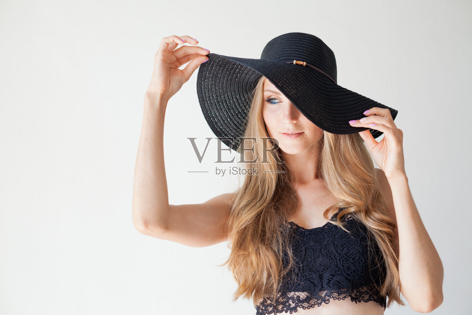 漂亮的女孩戴着一顶有帽檐的时髦帽子照片摄影图片