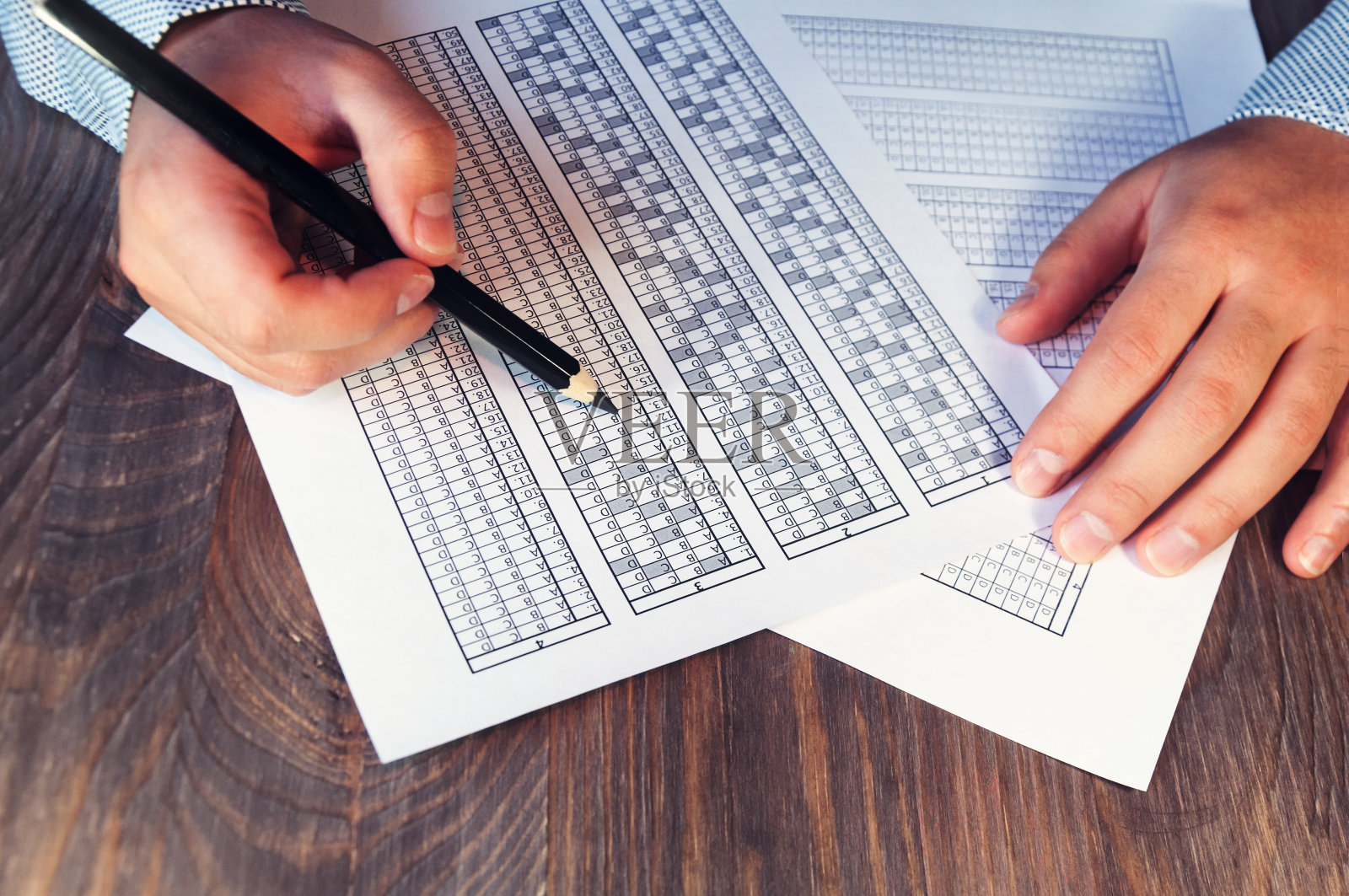 桌子上的人面前摆着考试表格。培训和招聘的测试。右撇子和左撇子。有选择性的重点。爽肤水照片摄影图片