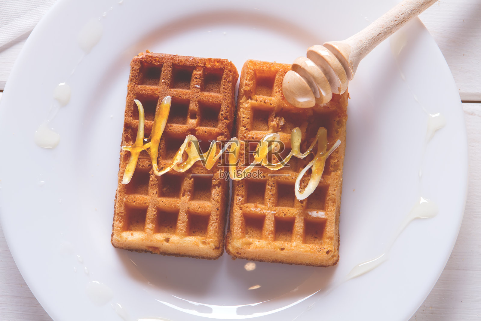 把蜂蜜倒在华夫饼上照片摄影图片