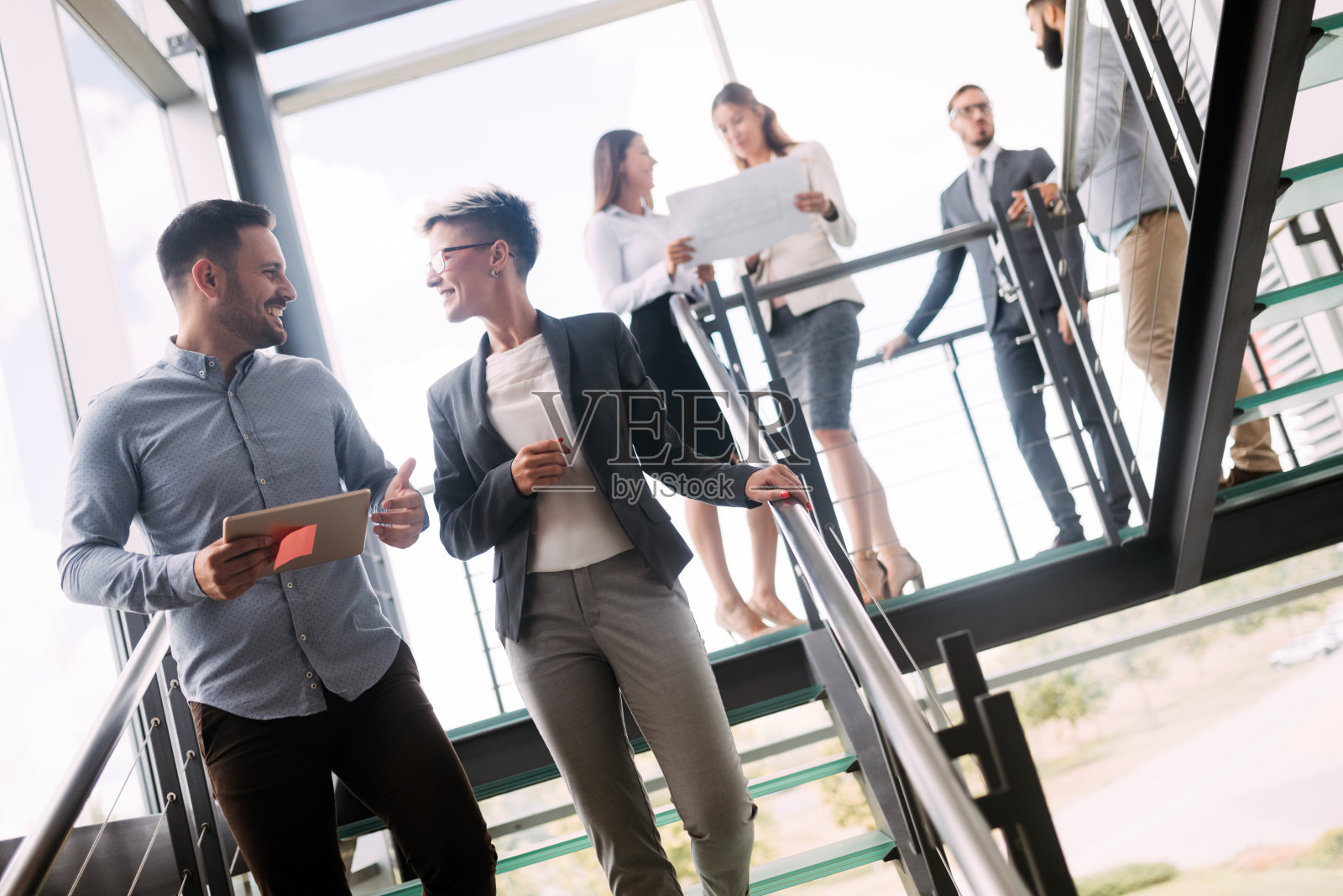 图为建筑师在大厅谈论项目照片摄影图片