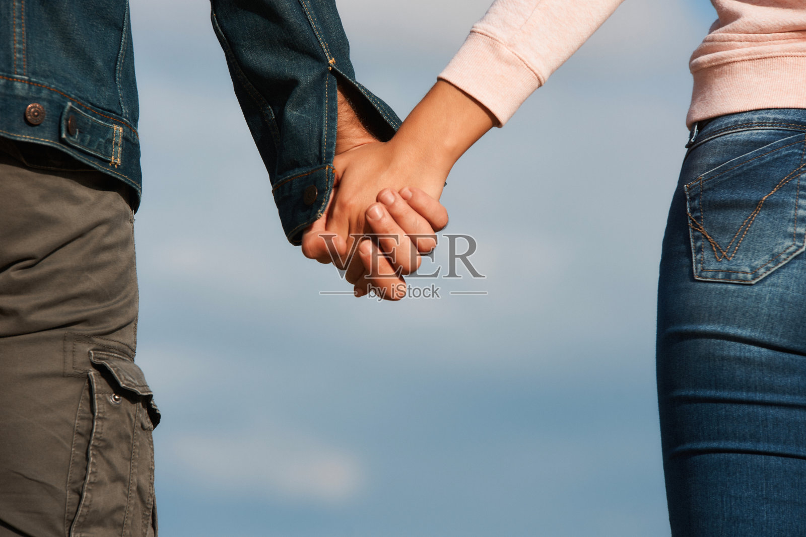 牵手的夫妇在蓝天的背景照片摄影图片
