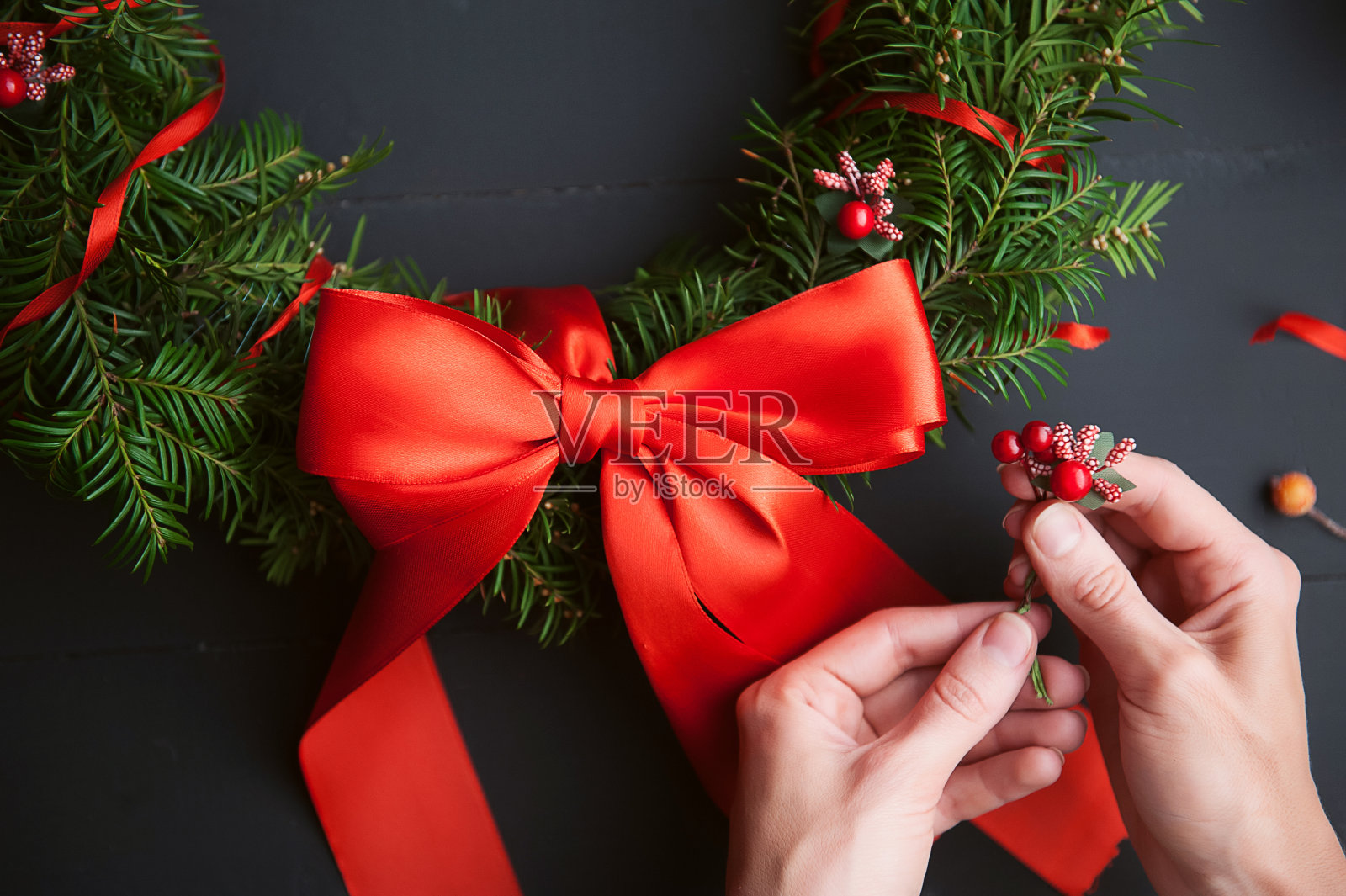 妈妈用她自己的手做了一个圣诞花环照片摄影图片