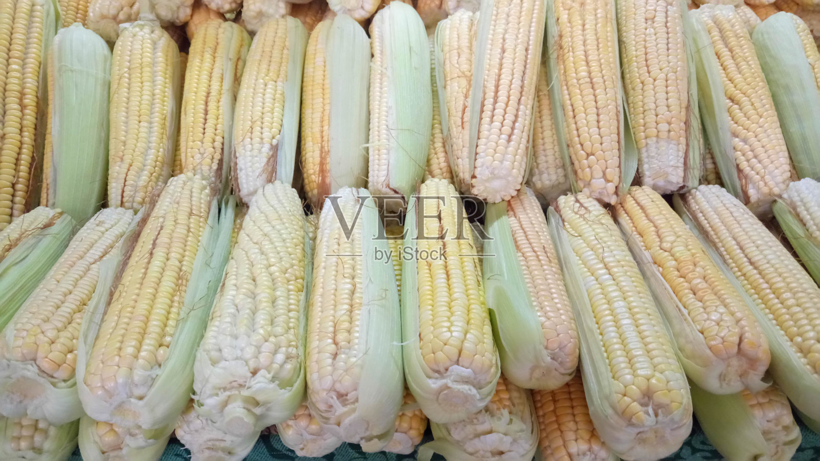 摆放于街市档位待售的甜玉米照片摄影图片