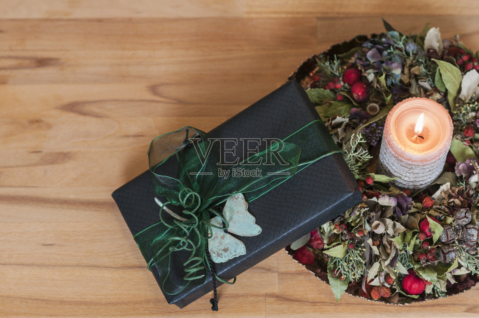 木头背景前的礼物和燃烧的蜡烛照片摄影图片
