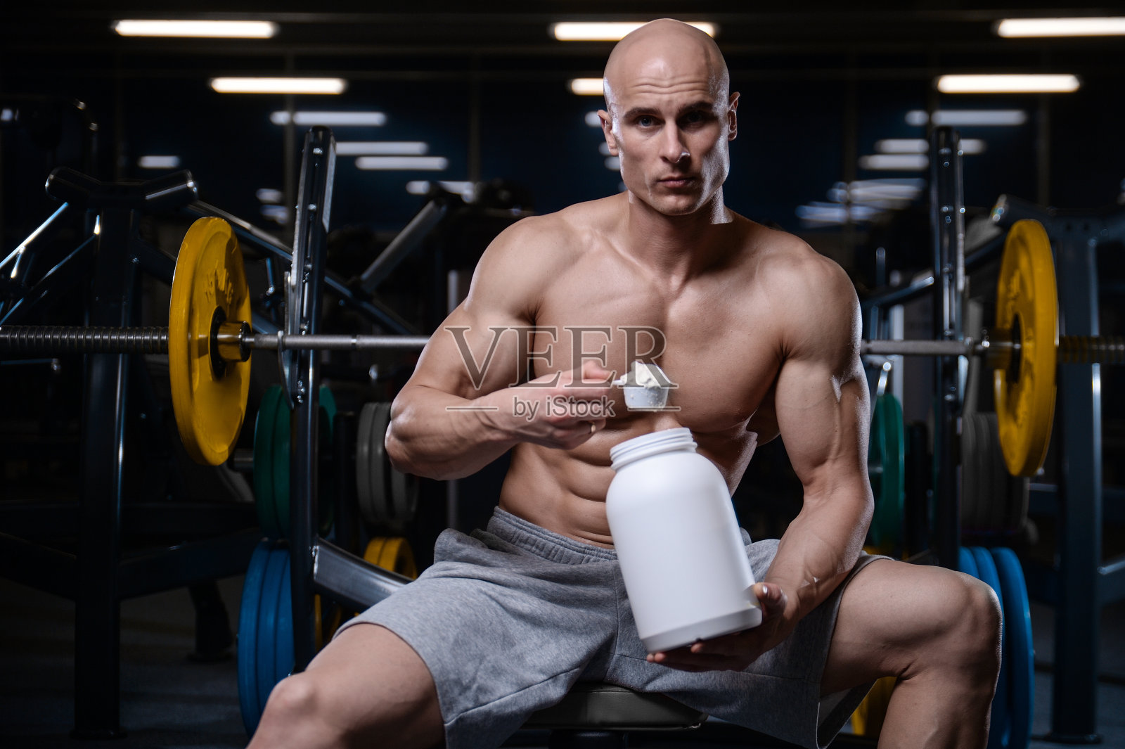 野蛮强壮的健美运动员用哑铃锻炼肌肉照片摄影图片