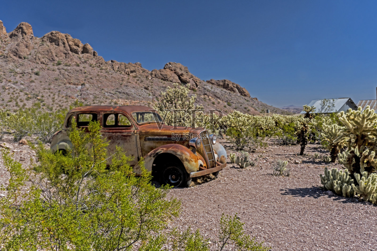 一辆旧的乡村汽车被遗弃在沙漠里。照片摄影图片